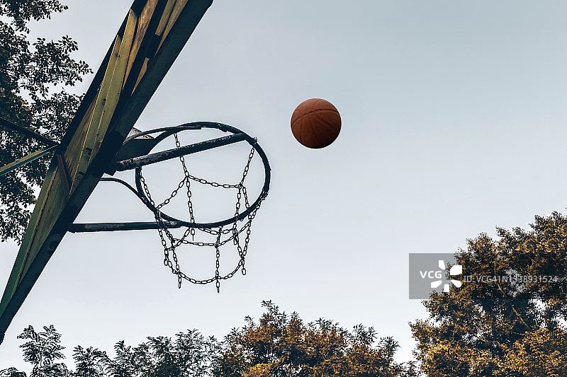 篮球和篮球篮在天空背景的户外。图片素材