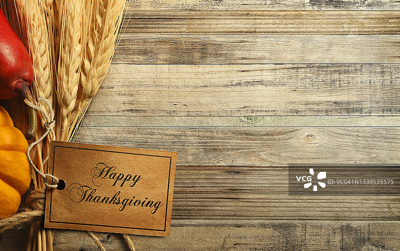 快乐的感恩节标签包裹在小麦秸秆风化木材表面图片素材