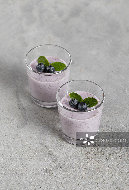 奶油浆果甜点，浅灰色玻璃蓝莓意式奶冻图片素材
