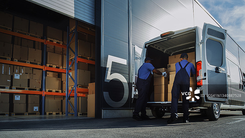 物流配送仓库外:两名工人装载纸箱运送卡车。在线订单，采购，电子商务货物。图片素材