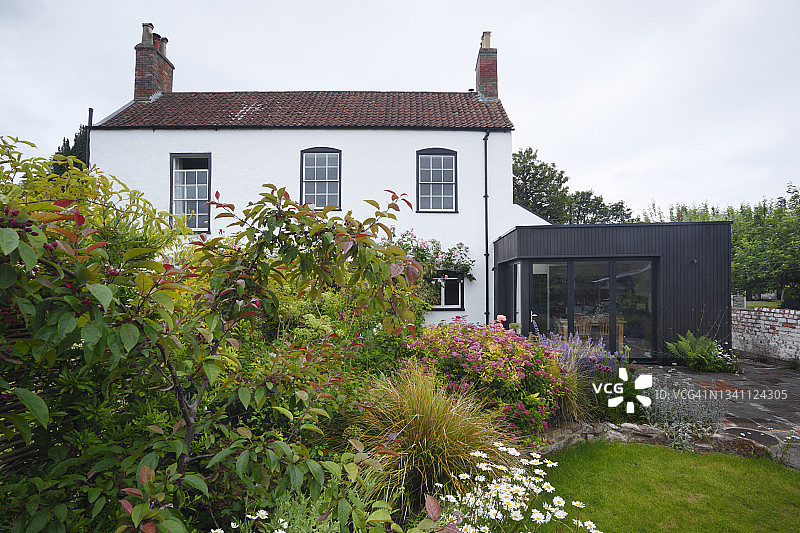 上市时期住宅与现代扩展和花园在夏天。英国布里斯托尔。图片素材