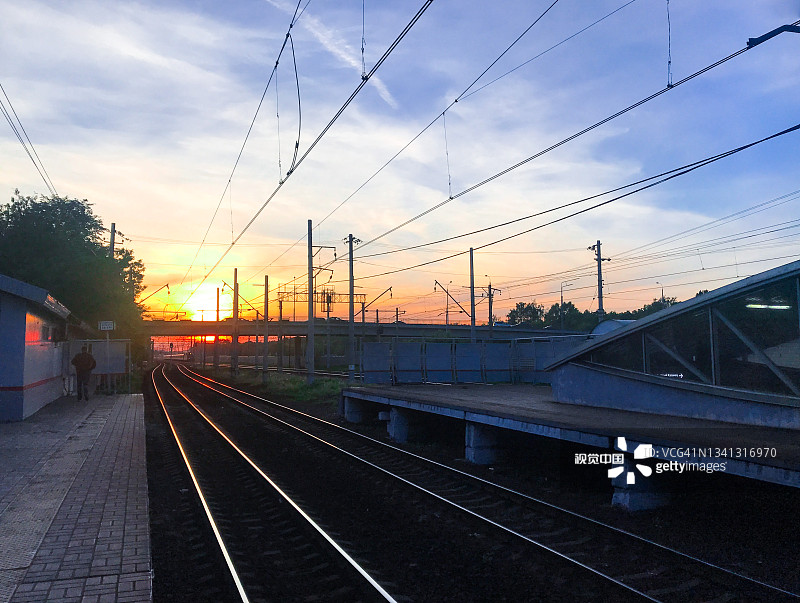 等待火车:夕阳从火车站的月台，郊区的一个小车站图片素材