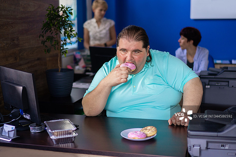 一个大男人在吃甜甜圈图片素材