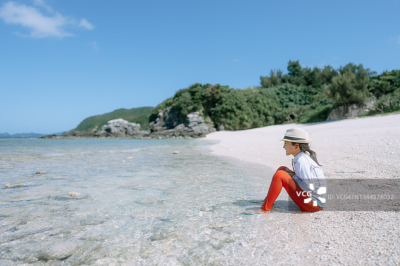年轻的女孩坐在海滩上，克拉马群岛，冲绳，日本图片素材