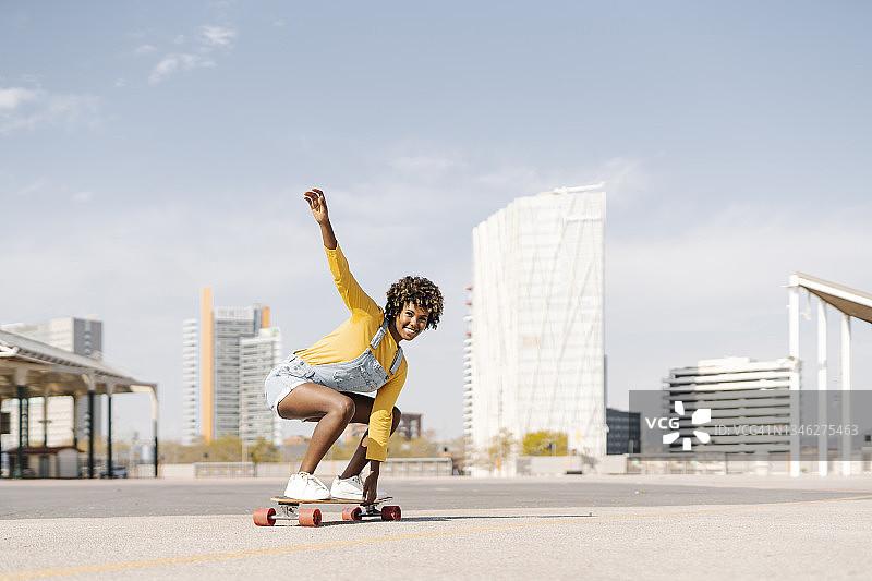 无忧无虑的非洲女人喜欢在城市的街道上骑滑板。图片素材