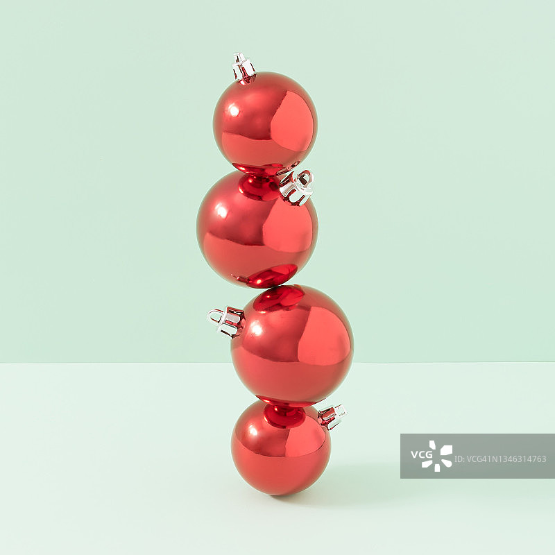 红色圣诞装饰球与明亮的绿色背景。最小的新年概念。创造性的节日审美。图片素材