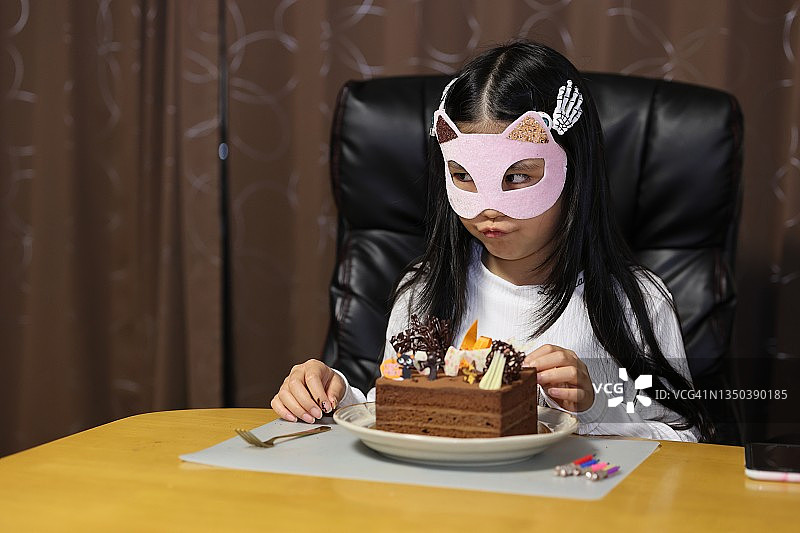 小女孩在家里与蛋糕万圣节图片素材