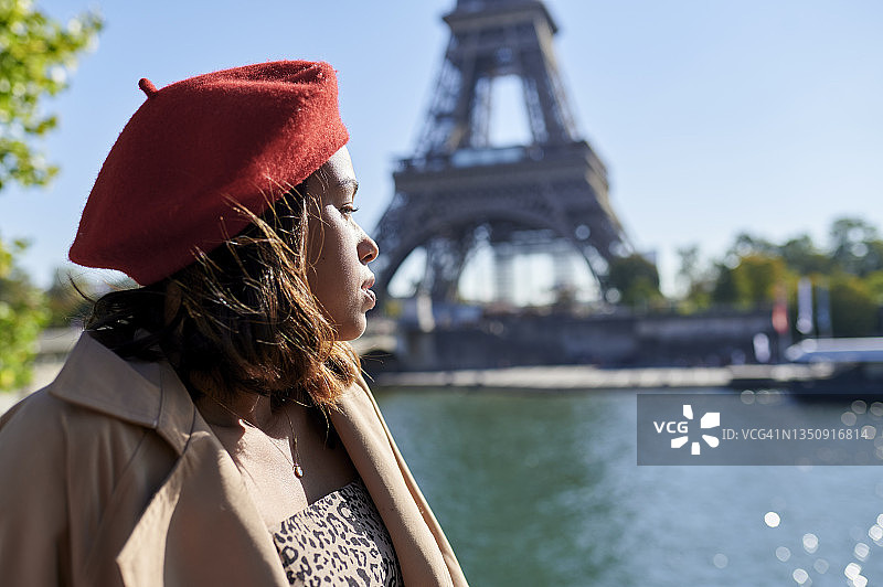 一名女子轻松地坐在巴黎埃菲尔铁塔旁图片素材