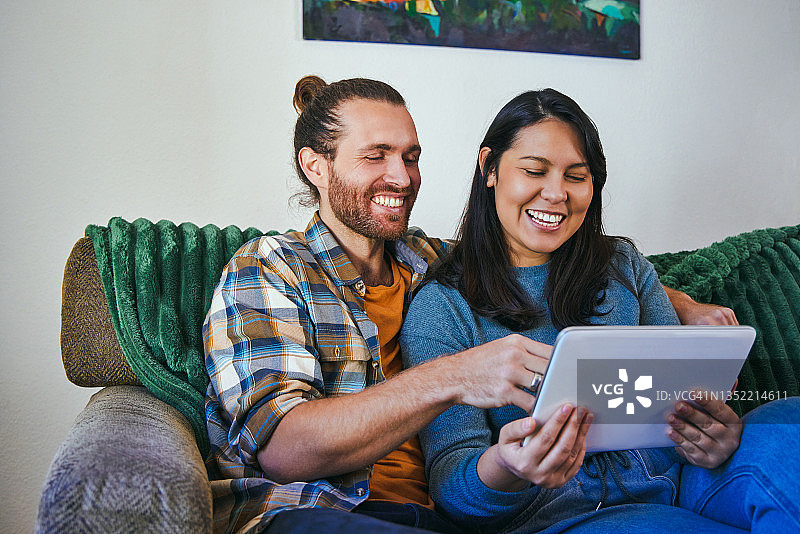一对年轻夫妇一起使用他们的电子平板电脑图片素材