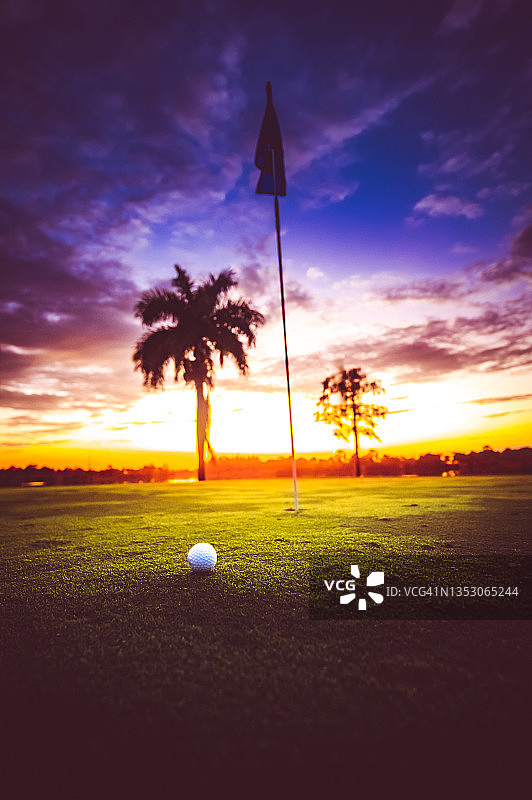 高尔夫球旁边的洞和令人惊叹的日落棕榈树剪影高尔夫在天堂图片素材