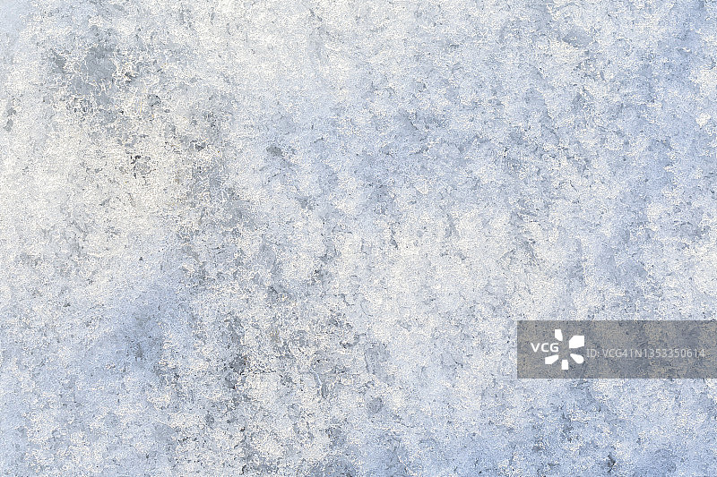 在一个阳光明媚的日子里，新鲜闪亮的雪在地面上的特写，俯视图。图片素材