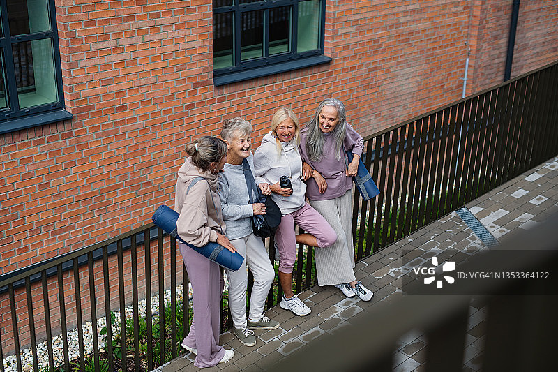 一群兴高采烈的老年妇女在城里户外运动后聊天。图片素材