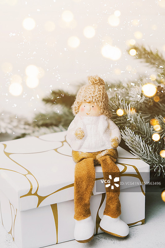 圣诞侏儒在礼品盒上的背景松枝与灯。图片素材