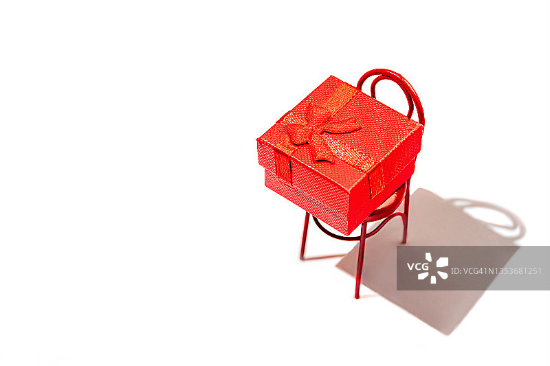 圣诞礼物，礼物，祝贺。冬季假期和黑色星期五的概念与礼品盒和红色椅子。图片素材