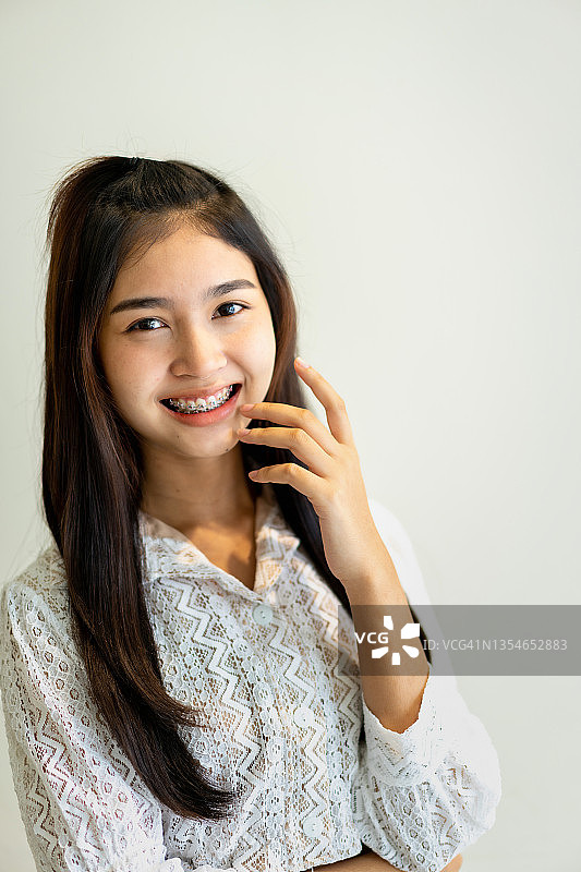 一个年轻微笑的亚洲女人的肖像牙齿矫正治疗。图片素材