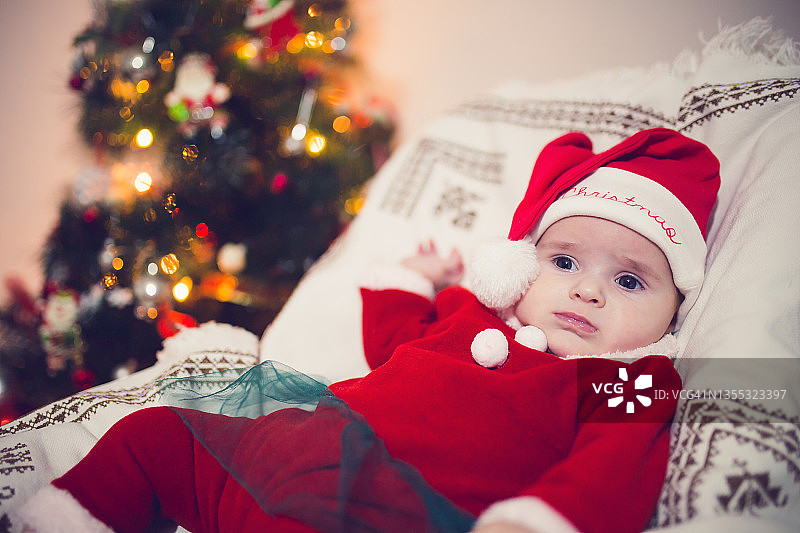 婴儿在圣诞树前休息图片素材