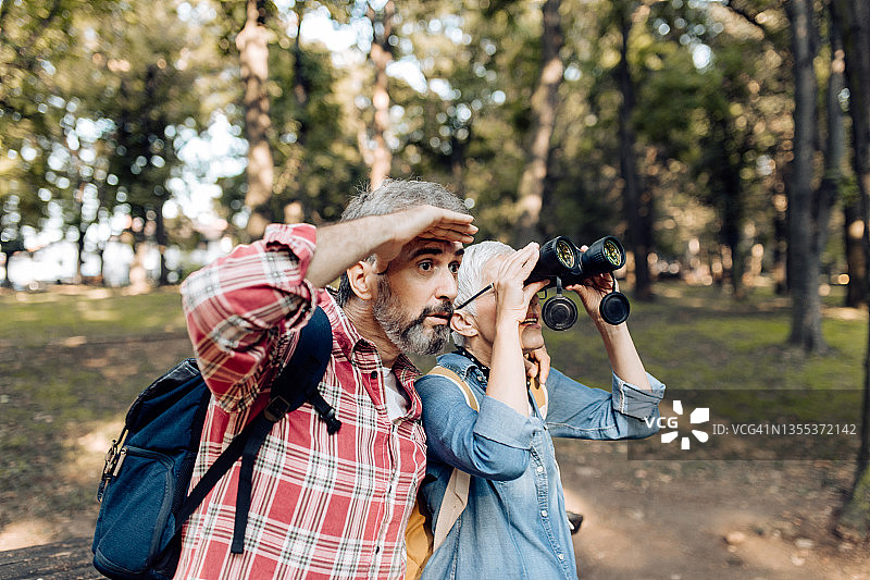 成熟的男人和女人用双筒望远镜探索自然，享受乐趣图片素材
