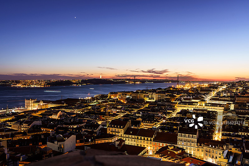 暮色笼罩在葡萄牙首都里斯本的城市景观上。图片素材