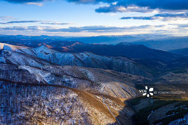 塞尔维亚的科帕尼克山脉。Kopainik国家公园。夕阳下的山，小山和草地。冬天的风景图片素材