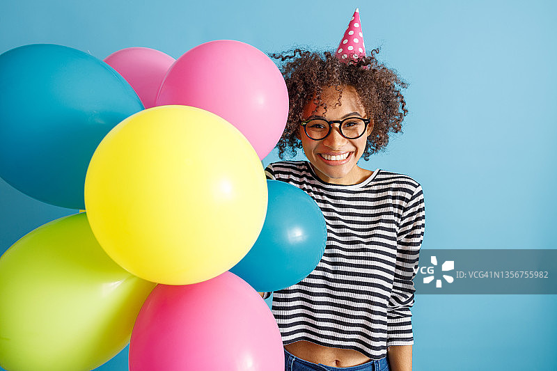 快乐快乐的女人与派对气球站在工作室图片素材