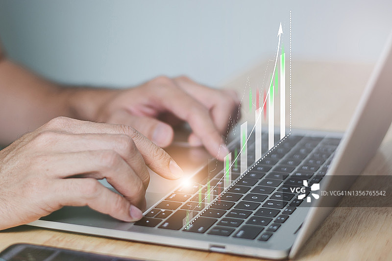 商人或交易员使用计算机与虚拟技术投资图表分析股票市场，银行财务和计划的概念。图片素材