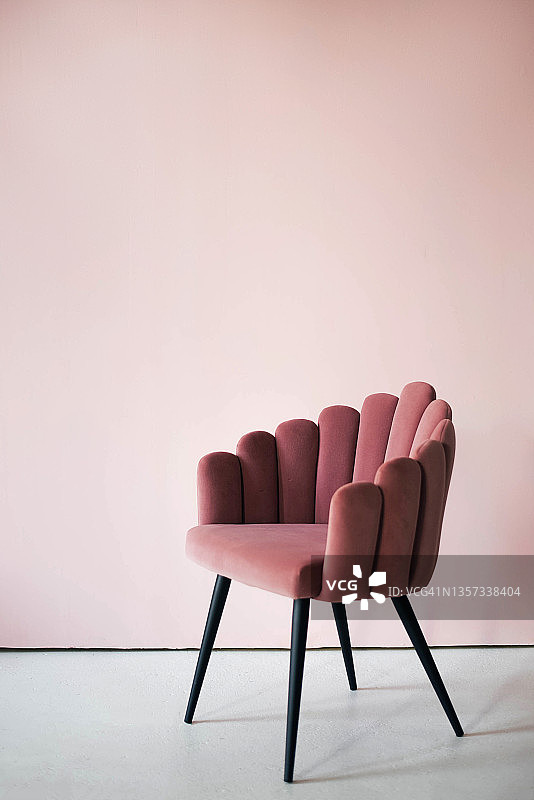 粉红色纹理天鹅绒扶手椅在粉红色的背景。图片素材