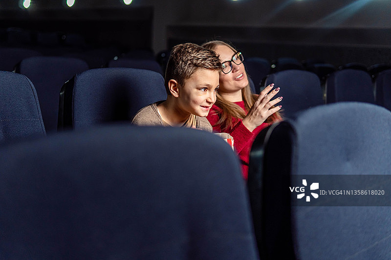 一位妇女和她的儿子在电影院享受图片素材