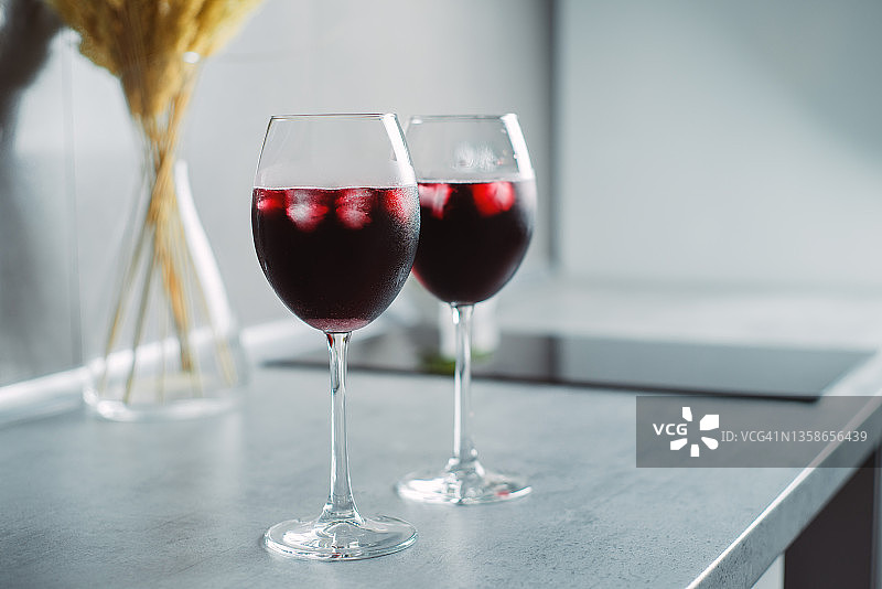 桌上放着盛有冰块的玻璃杯里的红酒图片素材