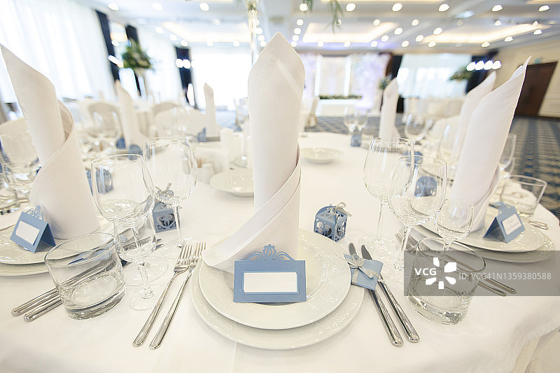 精美的婚礼宴会桌设置在餐厅与客人的名字。图片素材