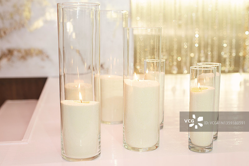 婚礼装饰在白色和金色风格的蜡烛和鲜花。图片素材