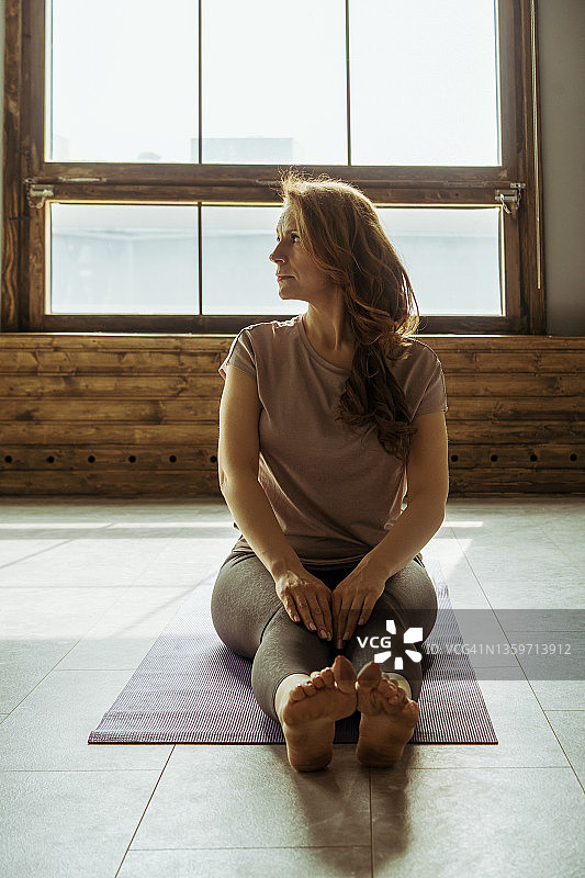 一个以瑜伽姿势坐着的中年妇女图片素材