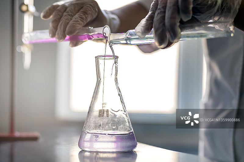 化学专家正在化学实验室的工作台上处理溶液和试管。是一种为科学或技术研究提供受控条件的设施。图片素材