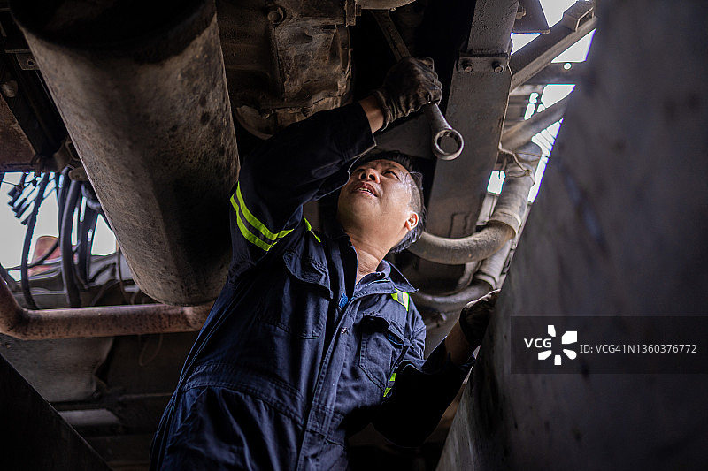 亚洲中国机械师在修理厂检查卡车底盘图片素材