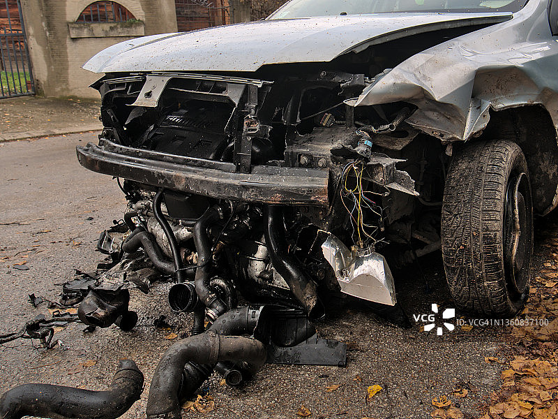 一场车祸后，汽车前部被撞得粉碎，零件散落在街上图片素材