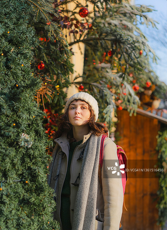 一个女人走在市中心的圣诞树旁图片素材
