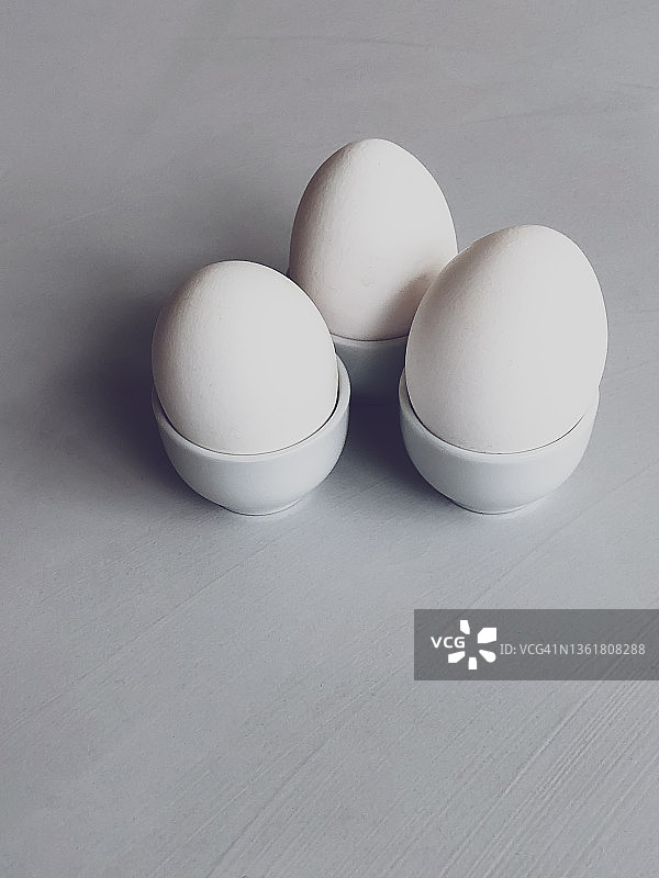 灰色背景上的三个鸡蛋。图片素材