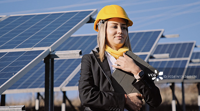 在太阳能发电厂工作的女工程师。可再生能源系统。太阳能城市。图片素材