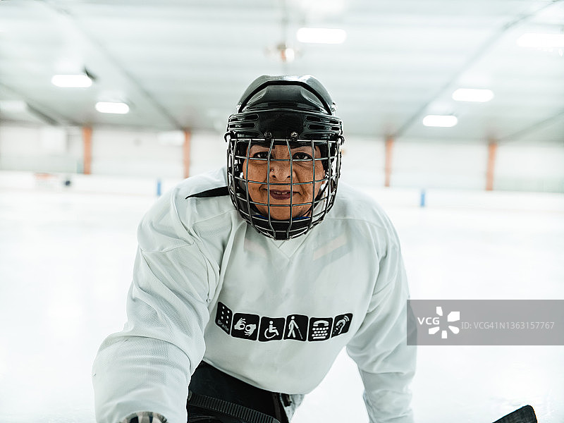 成年残疾拉丁女子玩雪橇曲棍球图片素材