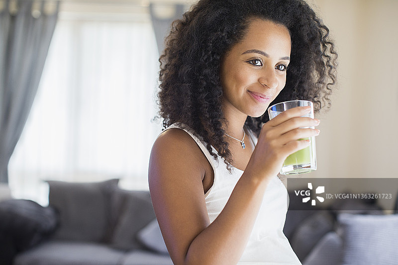快乐的年轻孕妇喝绿色奶昔图片素材