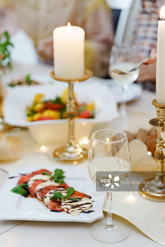 节日桌上摆满了食物、美酒和蜡烛。图片素材