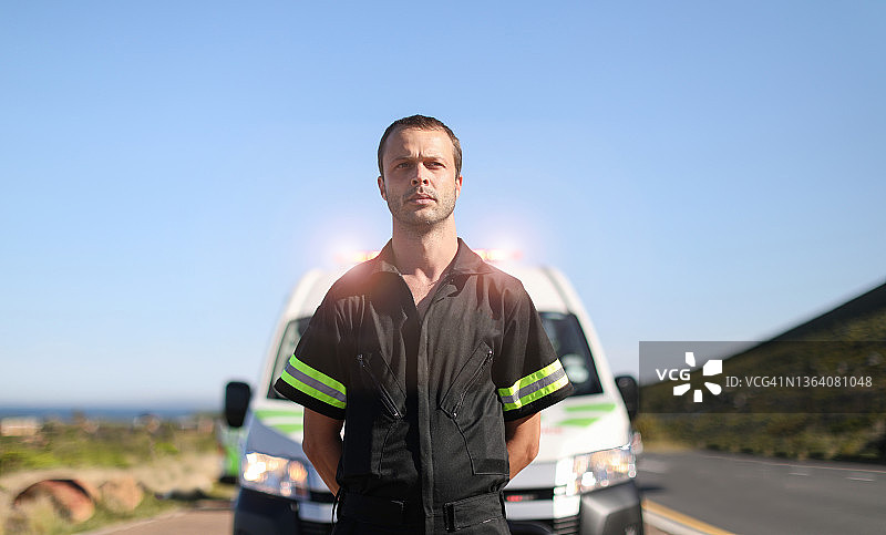 一名男性护理人员站在他的应急车辆前。图片素材