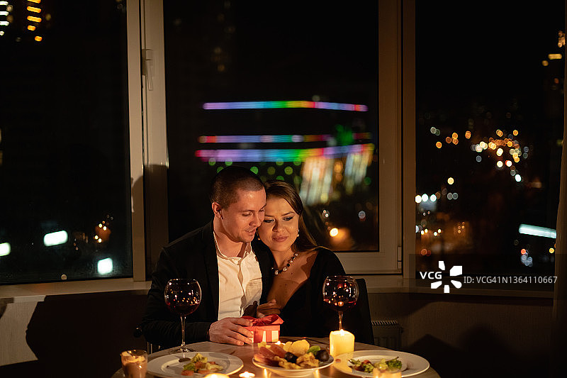 情人节的约会与蜡烛和葡萄酒，浪漫的晚餐两个人，男人和女人在餐厅晚上的烛光，夫妇结婚纪念日图片素材