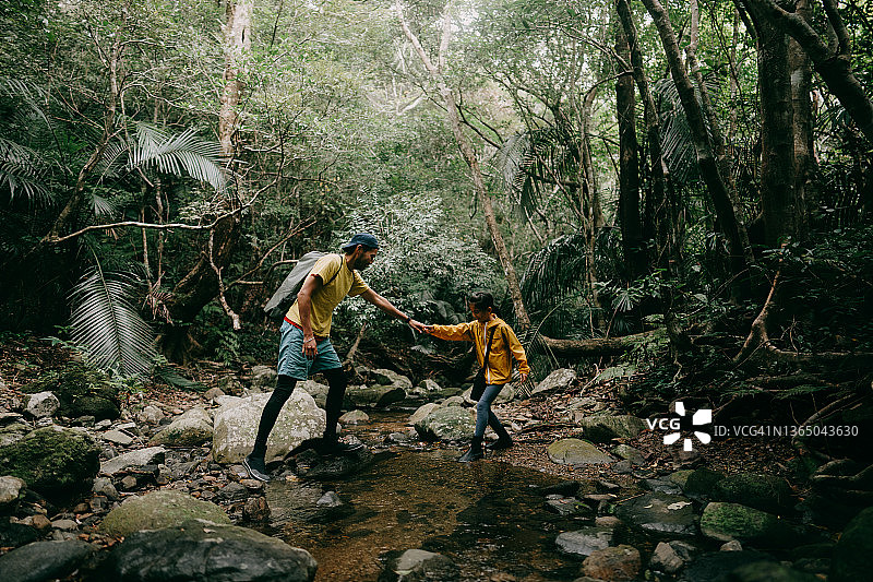 父亲和小女儿在河边的丛林里徒步旅行图片素材