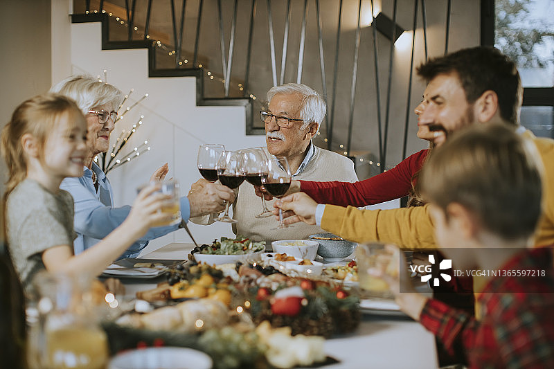 幸福的一家人在家里吃晚餐，喝红酒图片素材