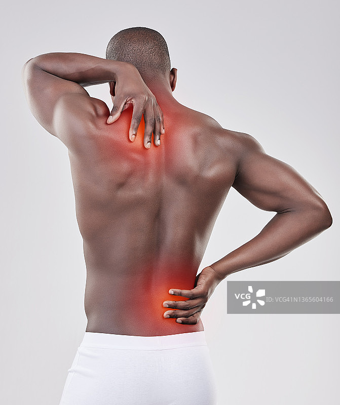 一名男子在工作室背景下经历背部疼痛的照片图片素材