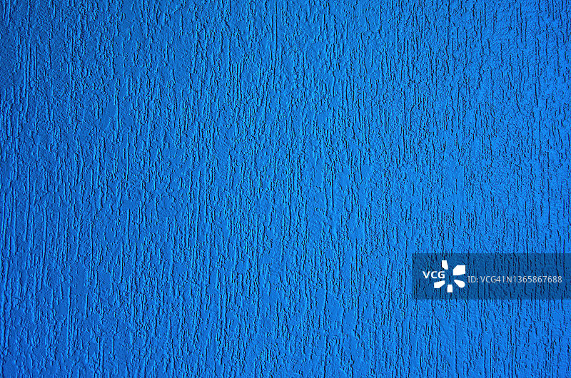 纹理不均匀的灰泥墙漆成中蓝色图片素材