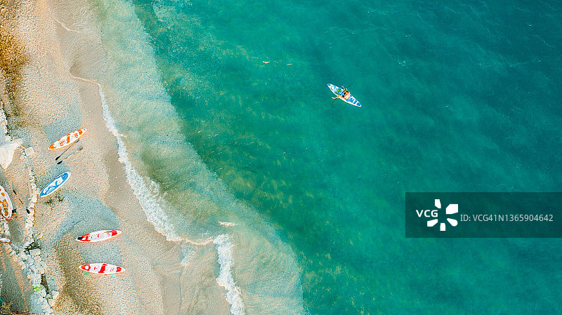 鸟瞰阿尔巴尼亚，男子在碧绿的大海上划皮艇图片素材