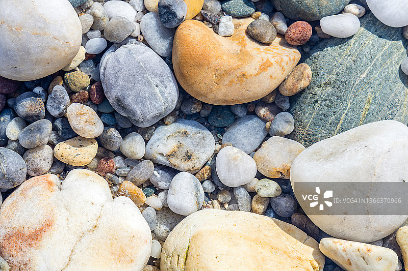 沙滩上潮湿的彩色石头的特写图片素材