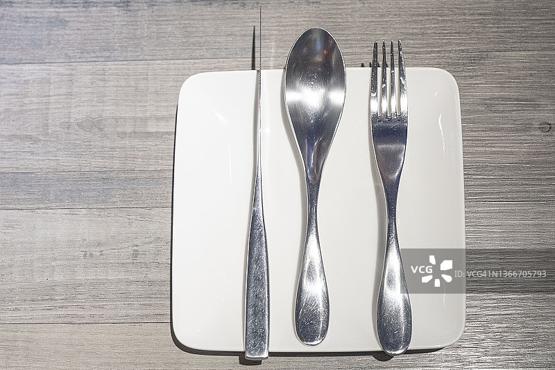 空盘子桌子设置与叉子勺子和刀在白色的盘子图片素材