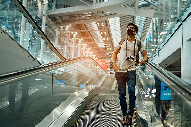 新常态和保持社交距离的概念。在病毒大流行期间，在候机楼等待登机保护冠状病毒(covid-19)的旅客商人戴着口罩图片素材